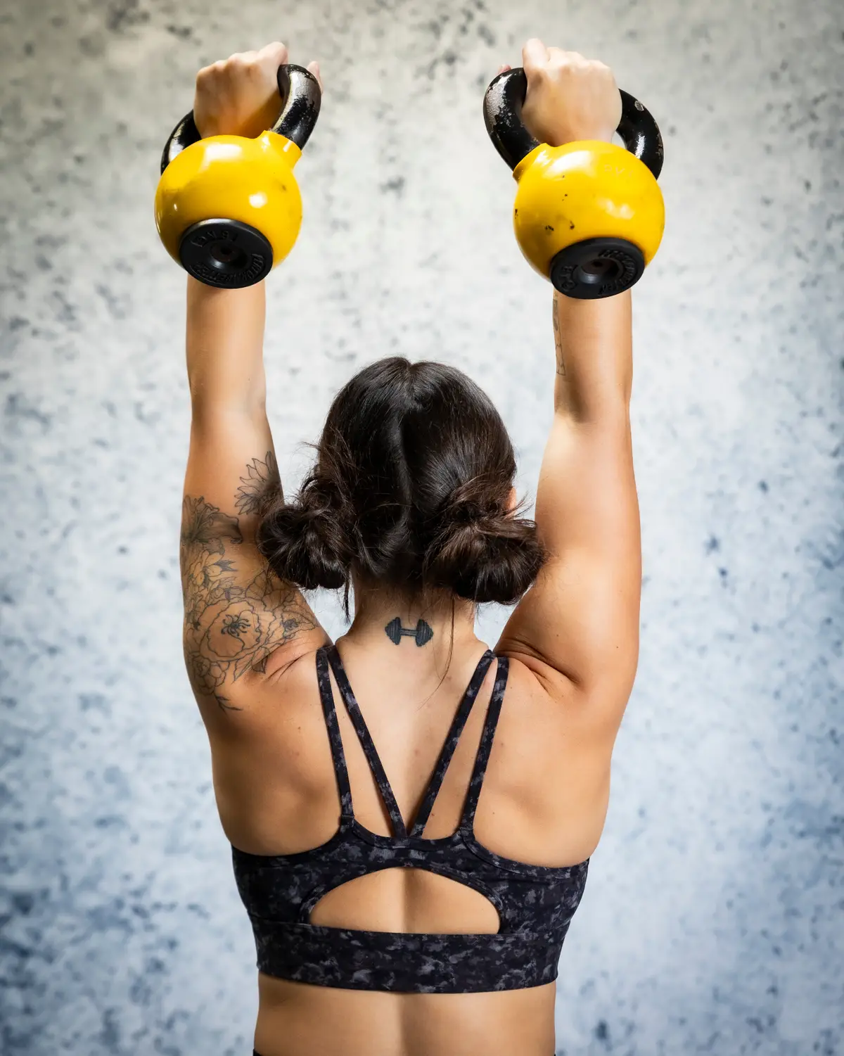 HealthSPORT athlete pressing kettlebells overhead