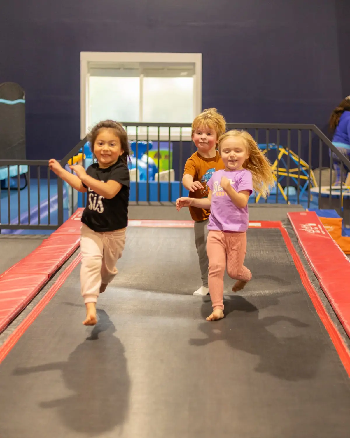 Three preschoolers running down the tumbling strip at HealthSPORT Gymnastics Fortuna