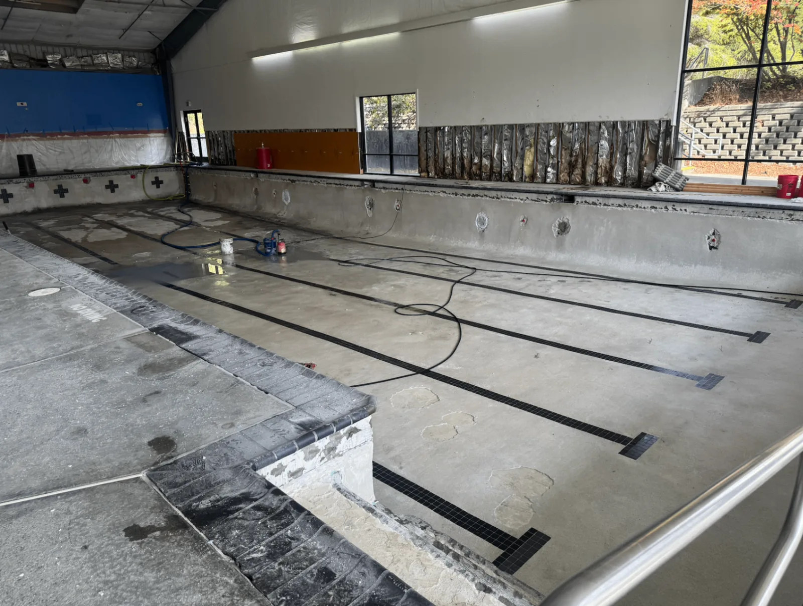 Drained Arcata pool with lane lines visible during surface preparation