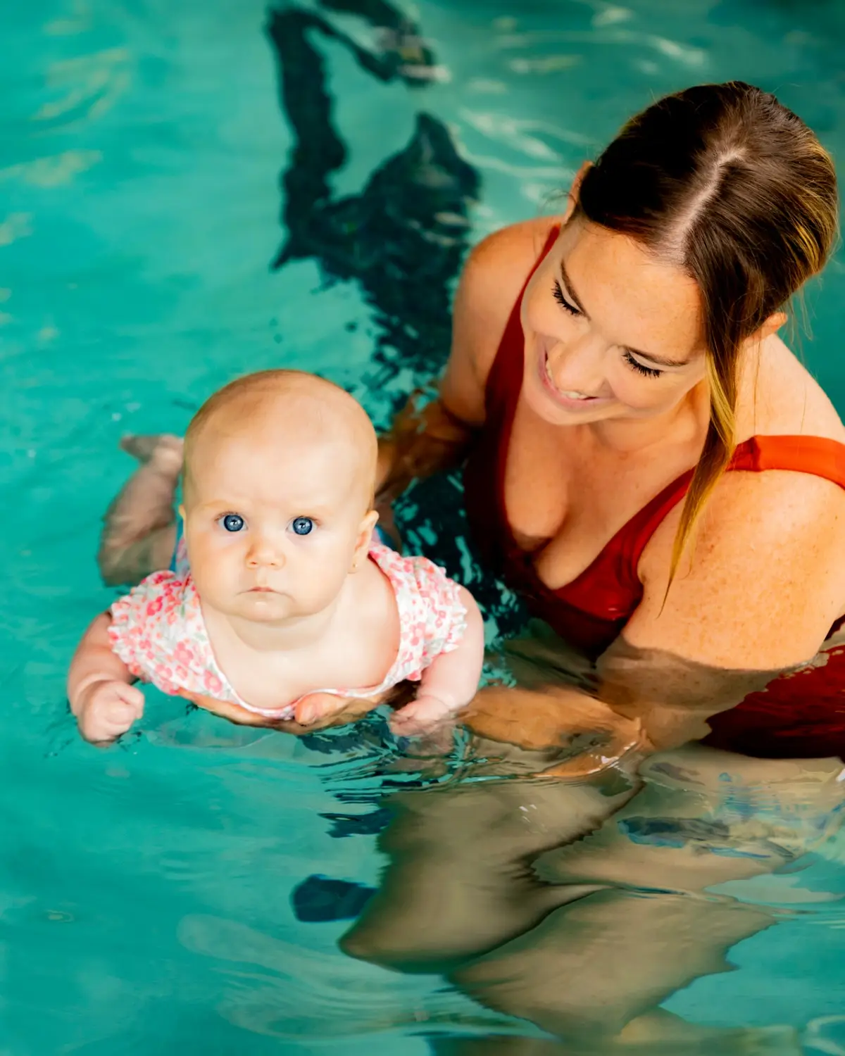 Instructor with infant learning to float