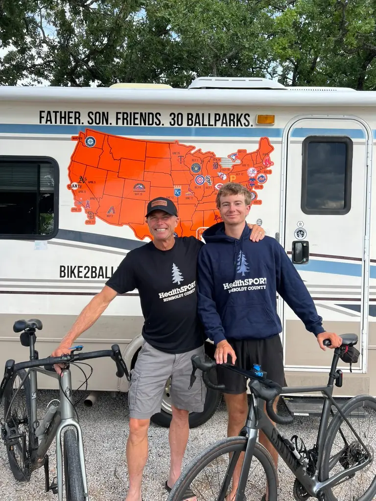Father and son cyclists in HealthSPORT gear on their 30-ballpark ride
