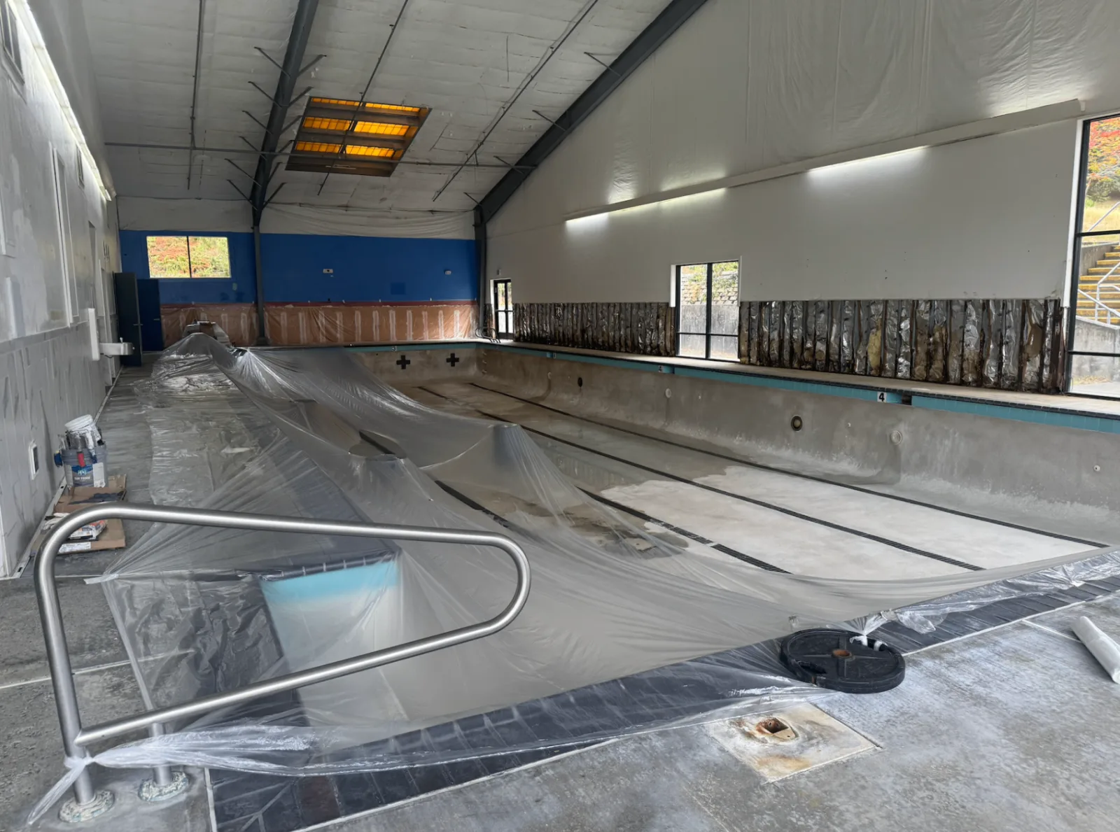 Wide view of the Arcata pool deck with protective sheeting covering part of the pool during renovation
