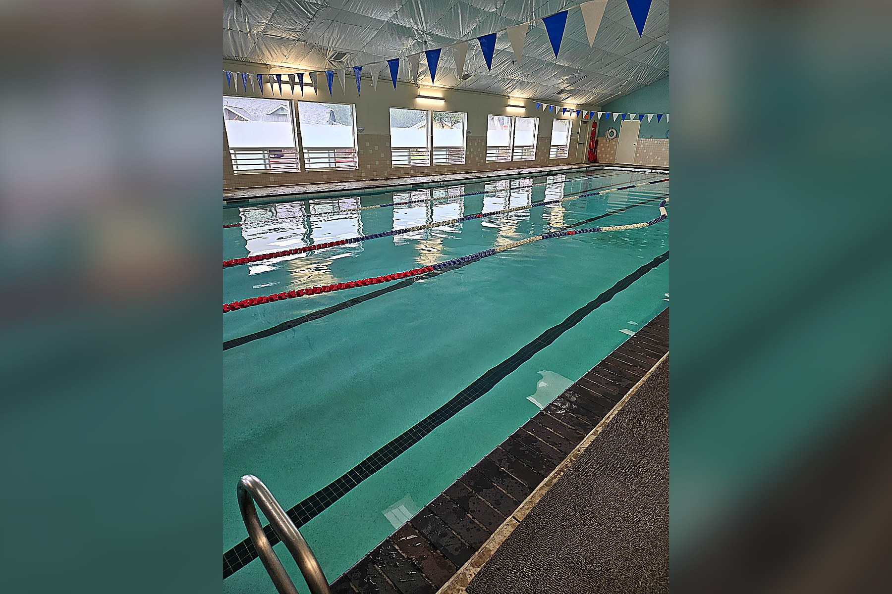 Heated indoor lap pool with lane lines and blue pennants