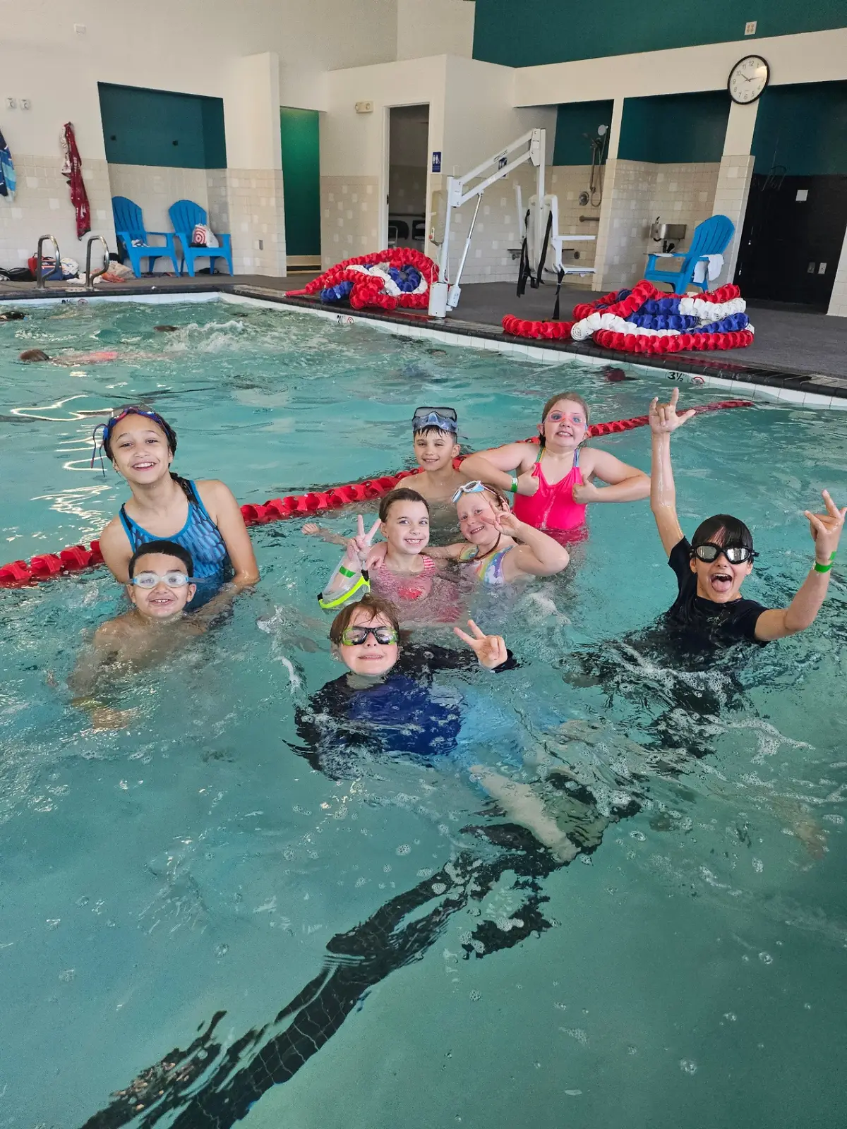 Summer swim camp group cheering in the pool