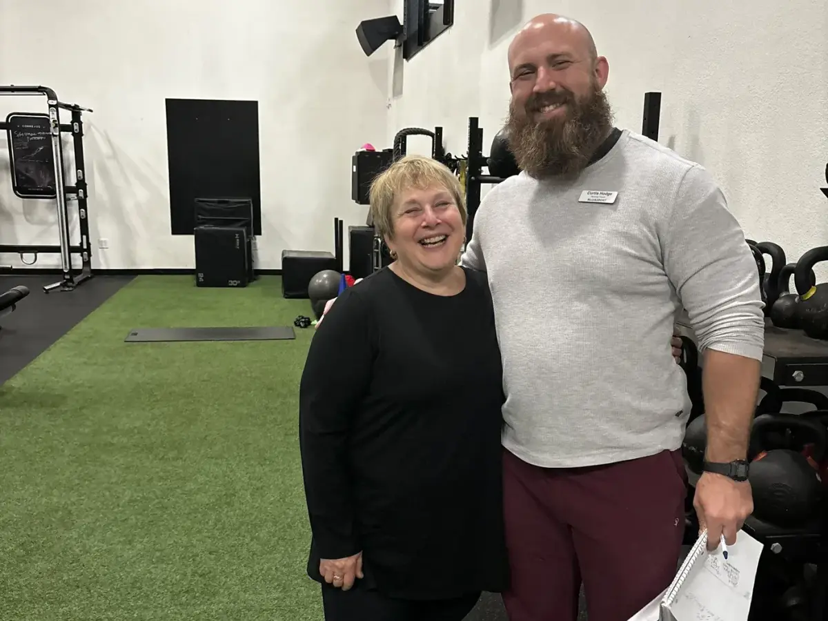 Longtime HealthSPORT member laughing with her personal trainer after a session