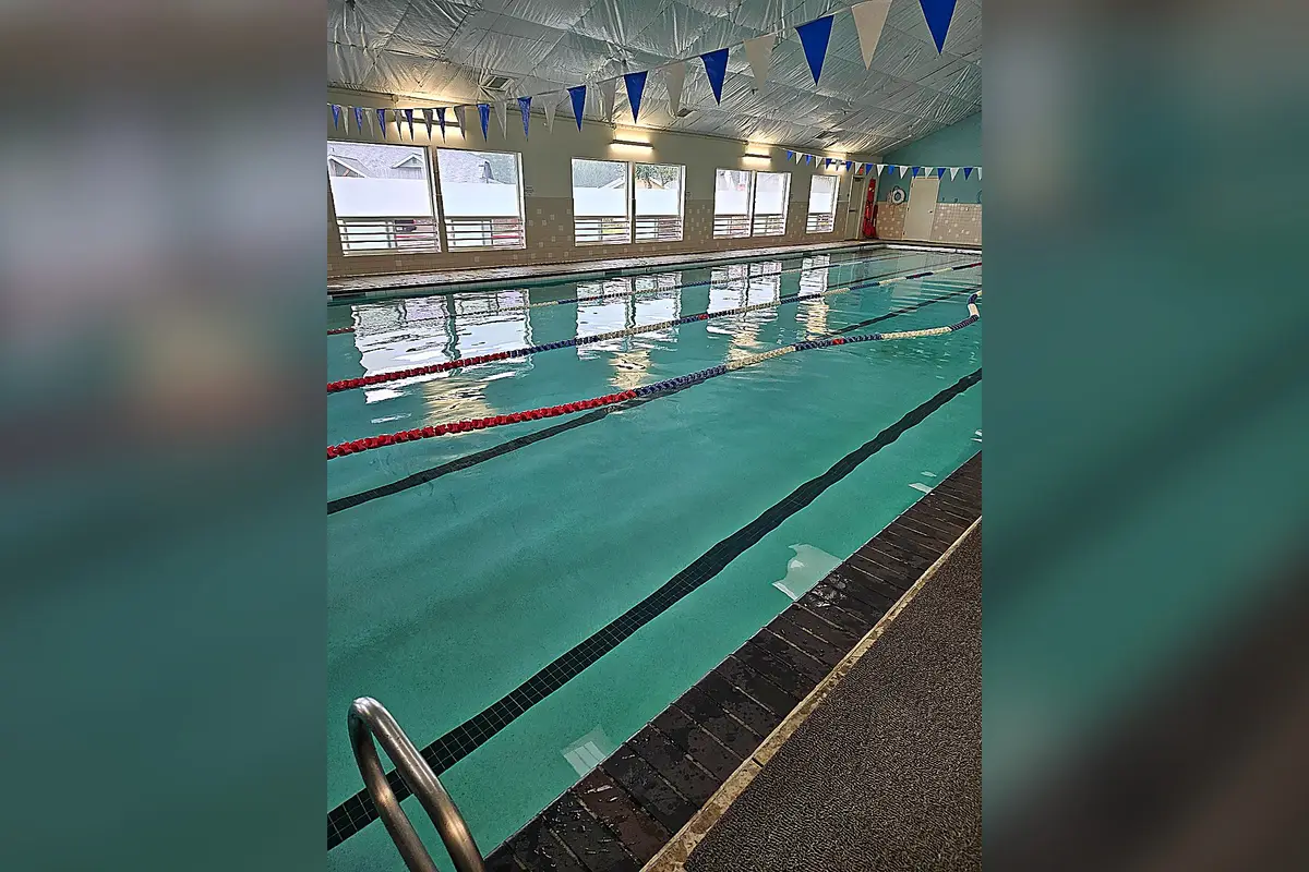 Heated indoor lap pool with lane lines and blue pennants